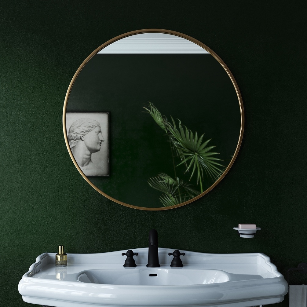 Lifestyle Image of the Origins Living Docklands 800mm x 800m Brushed Brass Round Mirror mounted on a dark green bathroom wall in front of a modern style basin B375660